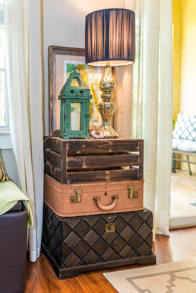 stacked boxes and trunks function as a table for a lamp and decor in las palmas condo st augustine