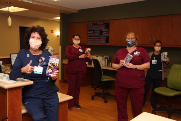 nurse holding cookies with girl scouts cookies for heroes program